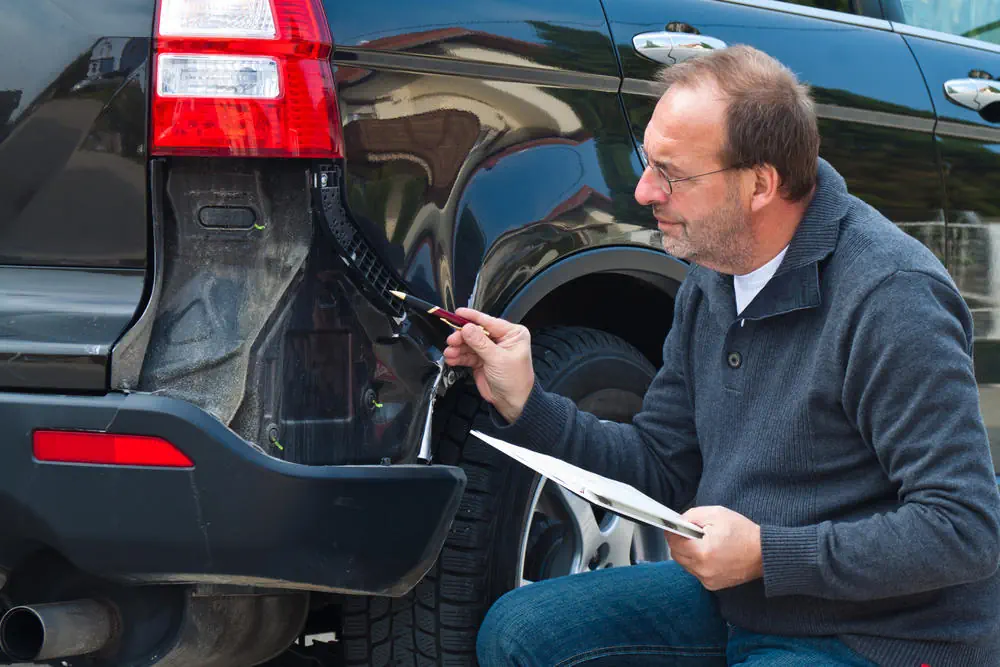 Versicherungsexperte Begutachtet ein Auto